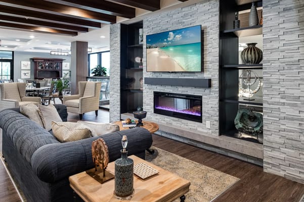 Living room with seating area, TV, and decorative fireplace.
