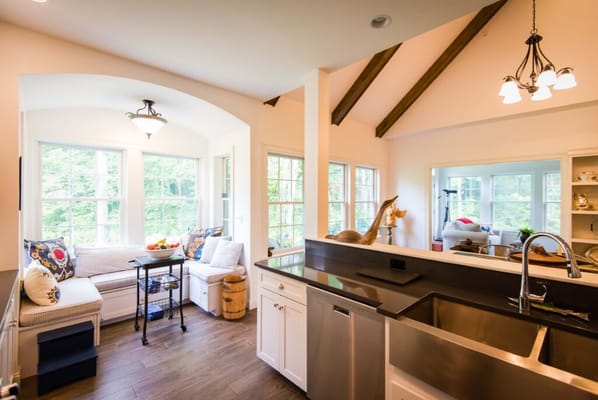 Bright kitchen sitting area with large windows and a cozy seating arrangement.
