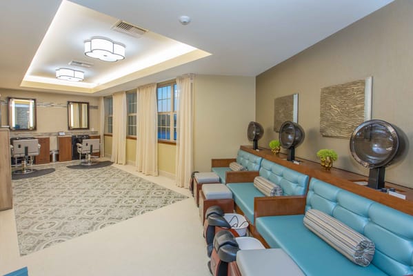Interior view of the salon area with chairs and hair dryers