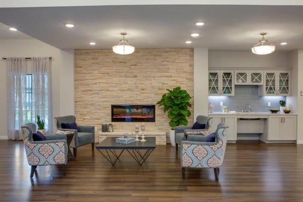 Inviting living room with chairs, a coffee table, and a fireplace.