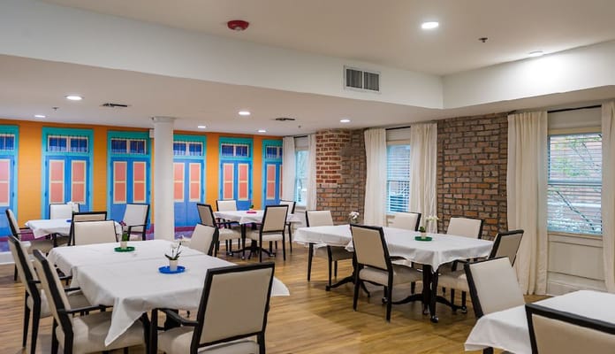 Bright dining area with tables and colorful windows
