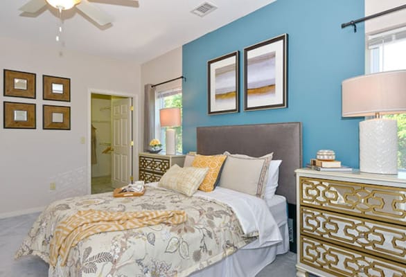 Stylishly decorated bedroom with a blue accent wall and floral bedding