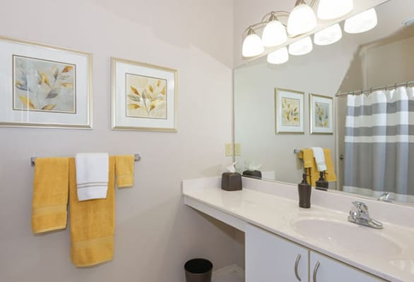 Bright bathroom with yellow towels and framed botanical art