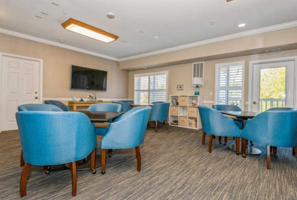 Bright common area with blue chairs and a television