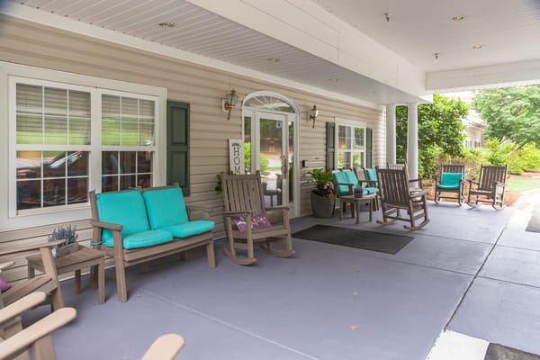 Comfortable porch seating with teal cushions at The Willows of Easley.