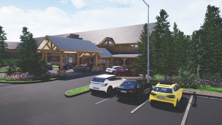 Exterior view of Timber Creek Senior Living entrance with parked cars and landscaped greenery.