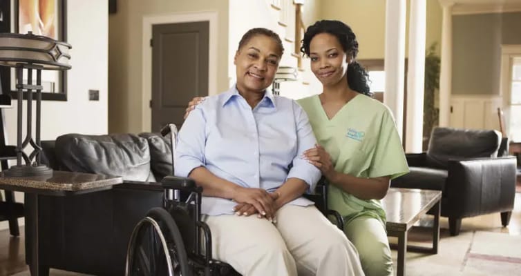 A caregiver and a resident smiling together in a cozy living space.