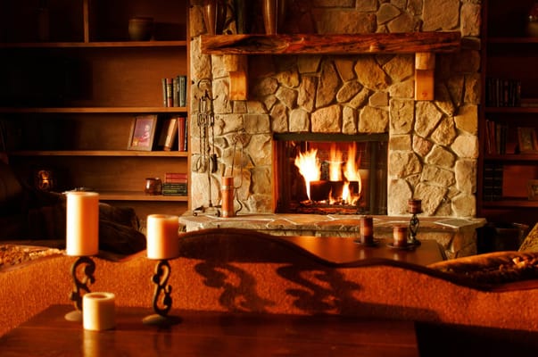 Warm fireplace with stone surround and candles