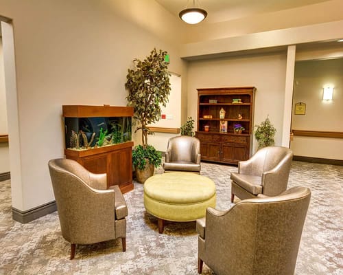 Comfortable seating area with aquarium and bookshelf