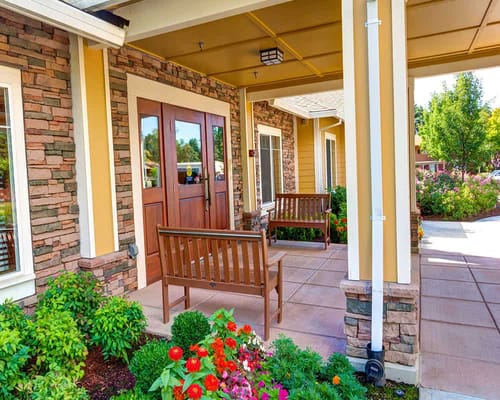 Front entrance with benches and flower beds at Washington Gardens Memory Care.