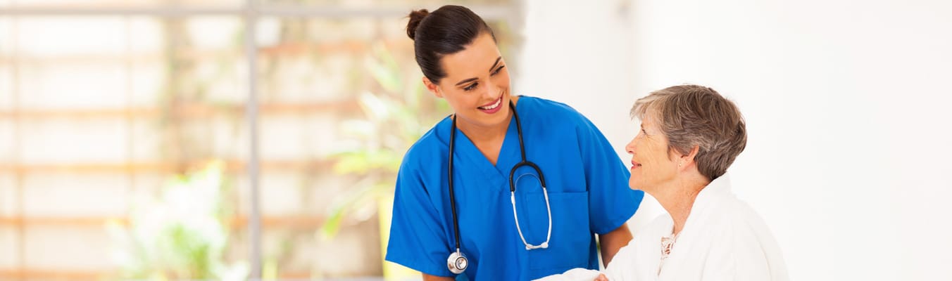 A caregiver assisting a senior resident in a bright interior
