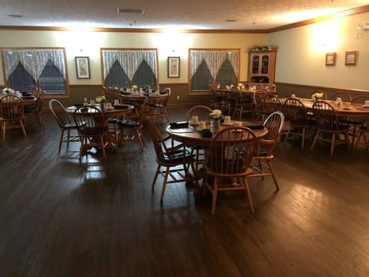 Wooden dining tables and chairs in a well-lit dining area.