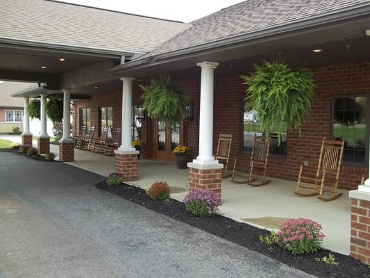 Entrance of Westbrook Assisted Living with rocking chairs and plants