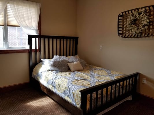 Comfortable bedroom featuring a bed with decorative pillows and a window.