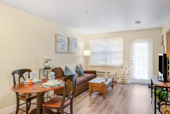 A cozy living room with a dining table and sofa in Windward Palms.