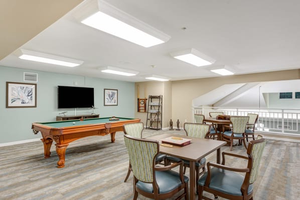 Bright game room featuring a billiard table and seating area