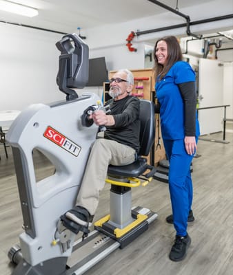 Resident using exercise equipment with staff support