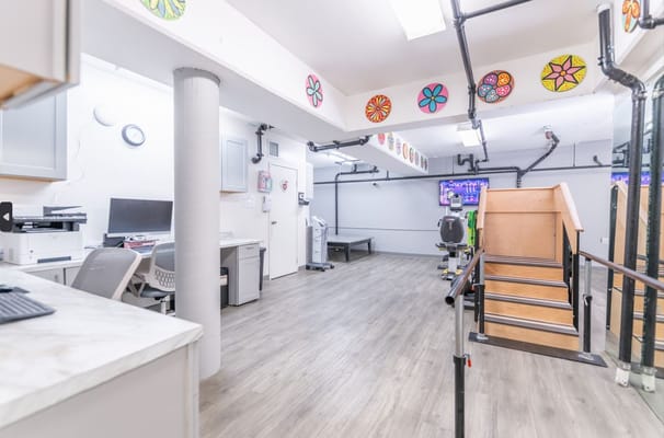 Well-lit therapy room with exercise equipment and decorations