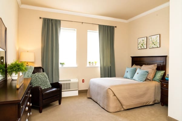Bedroom with a bed, armchair, and decorative plants