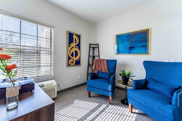 Brightly lit lounge area with chairs and art