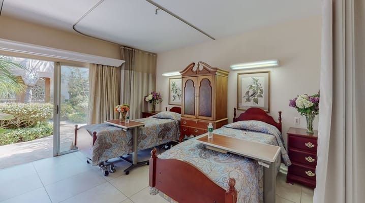 Bedroom with two beds, a chest of drawers, and a sliding door to outside.