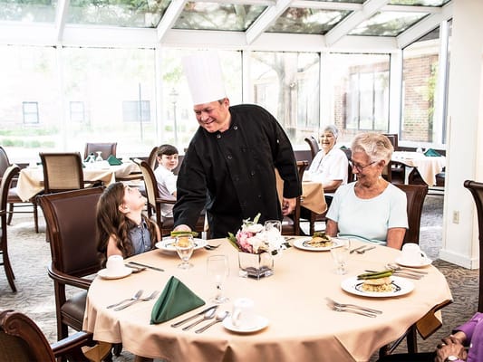 Chef serving residents in a dining room atmosphere