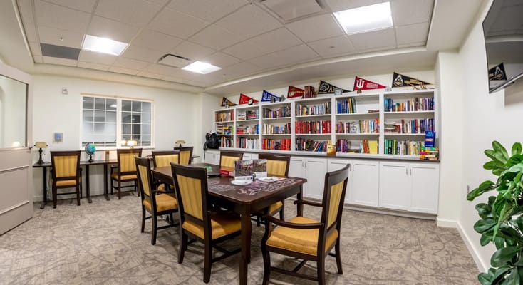 Cozy library space with bookshelves and dining tables