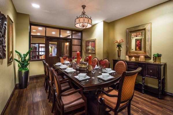 Spacious dining room with a large wooden table set for dinner