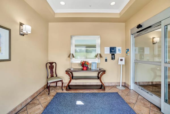 Cozy lobby area with a chair and table decorated with flowers