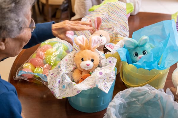 A resident interacting with stuffed bunnies during an activity