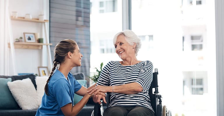 Resident smiling with staff in a bright interior