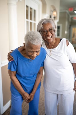 Two female residents sharing a joyful moment in the facility