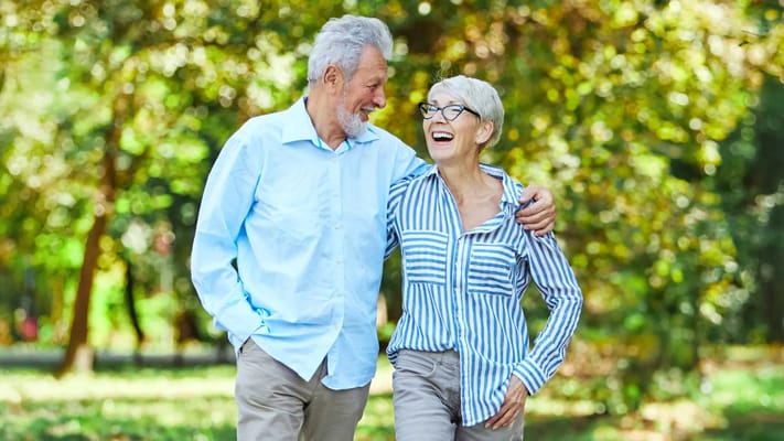 Two seniors walking together in a park
