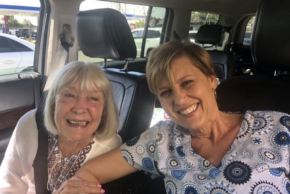 Two women smiling together in a vehicle