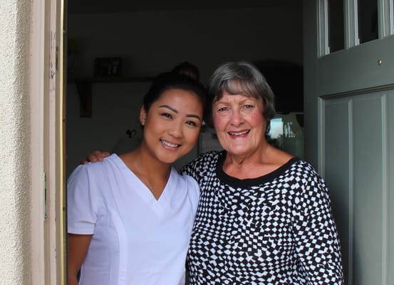 Staff member and resident smiling at the entrance