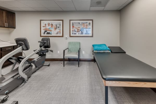 Therapy room with exercise equipment and framed photos of residents