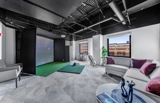 Interior view of a recreational space with seating and a simulation area