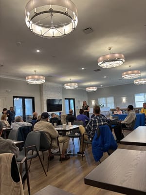 Residents and staff engaged in a group activity in the dining area