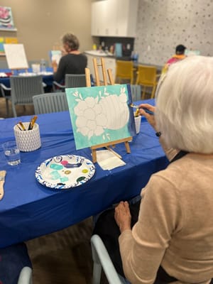 Resident painting in an activity room