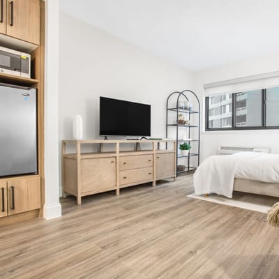 Bright, modern resident room with television and furnishings