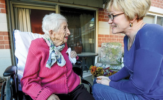 Elderly woman talking with caregiver outside