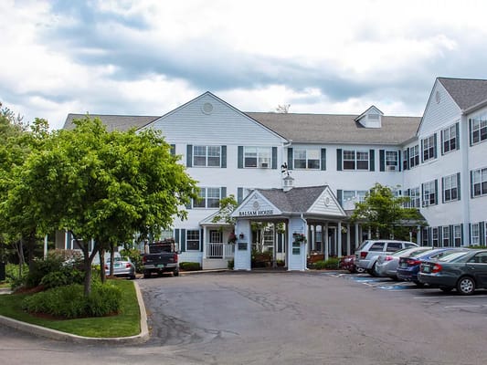 Entrance view of Balsam House with parking area and trees