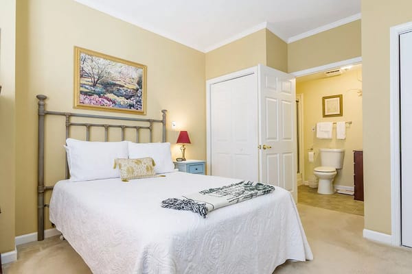 Comfortable bedroom with a bed, lamp, and bathroom access