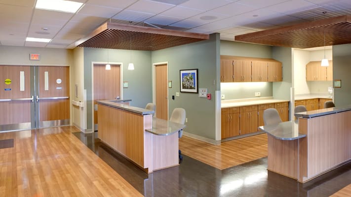 Reception area with wooden countertops and chairs in Riverwood Health Care Center.