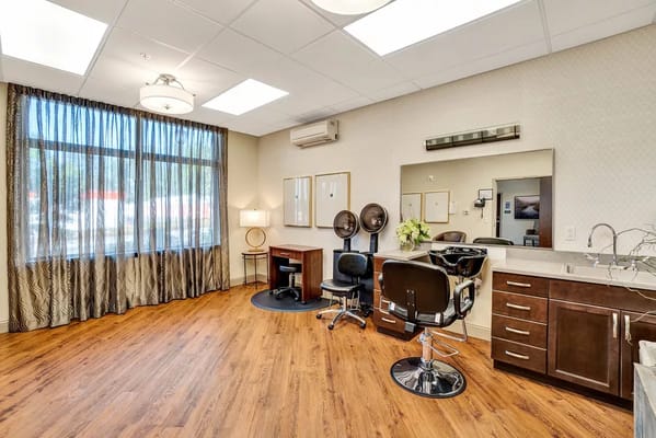 Salon area with styling chairs and large windows