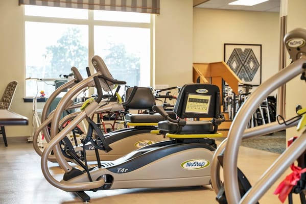 Row of NuStep exercise machines in a bright room