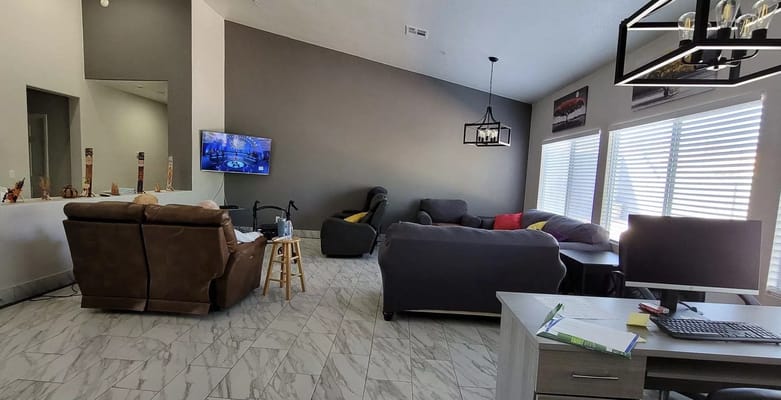 Common area with seating and a TV for residents