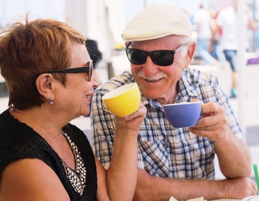 Senior couple happily toasting with coffee cups