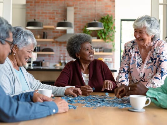 Residents enjoying a puzzle activity in a common area