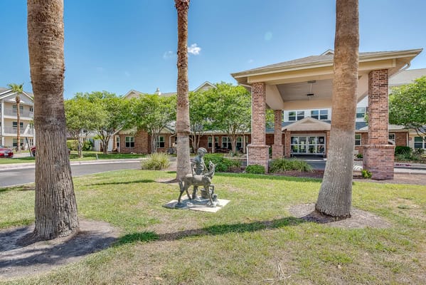 Exterior view of a senior living facility with palm trees